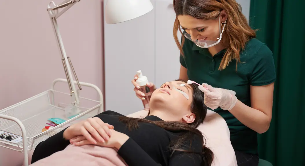 Aesthetic practitioner carefully administering an under-eye treatment to a client